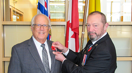 Mayor Malcolm Brodie is receiving a poppy from Matthew McBride, Chair of the Richmond Remembrance Day Committee