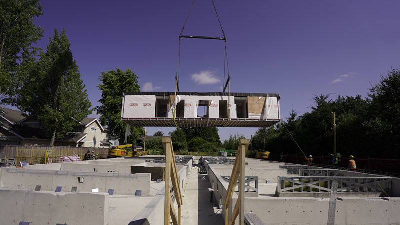 View of a beam being lifted over a construction site