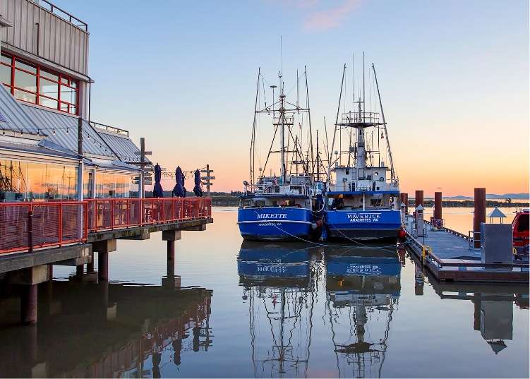 Two sailboats are berthed at Steveston Harbour at sunset