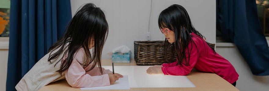 Two little girls drawing at a table