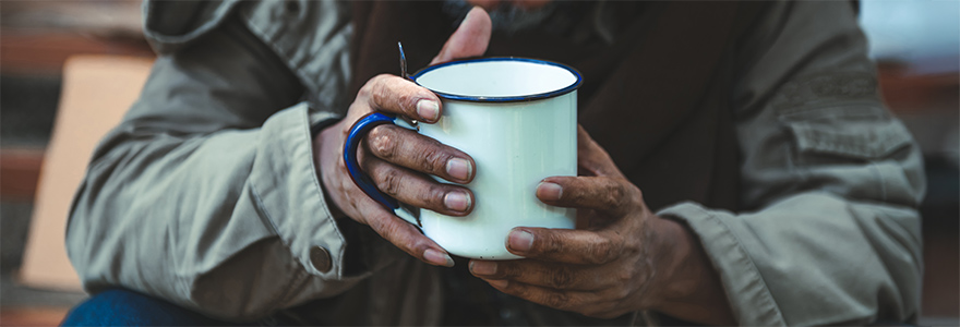 Closeup of man's hands holding a tin cup