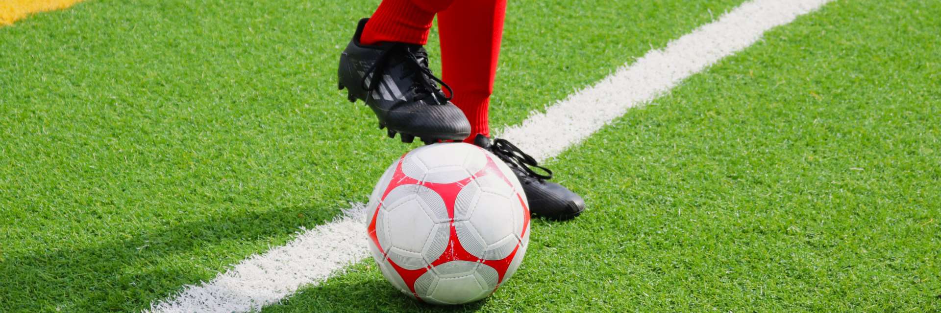 View of a youth playing soccer on Minoru field.