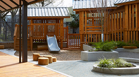 Exterior play space with slide and beautiful landscaping.