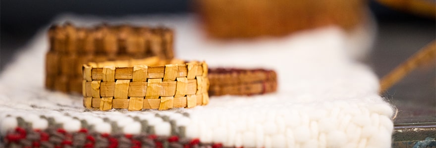 Close-up of three woven cedar bracelets on a wool blanket