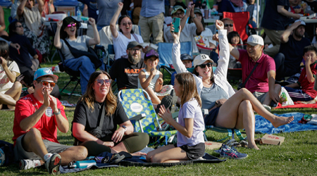 A group of people sitting on the ground at an event
