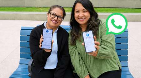 Two ladies holding up their phones to display the City's WhatsApp Channel