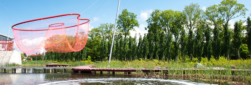 Public art installation of large red net over water